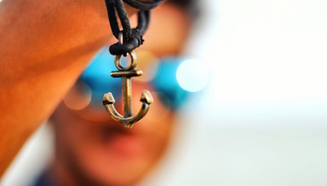selective focus photography of anchor pendant